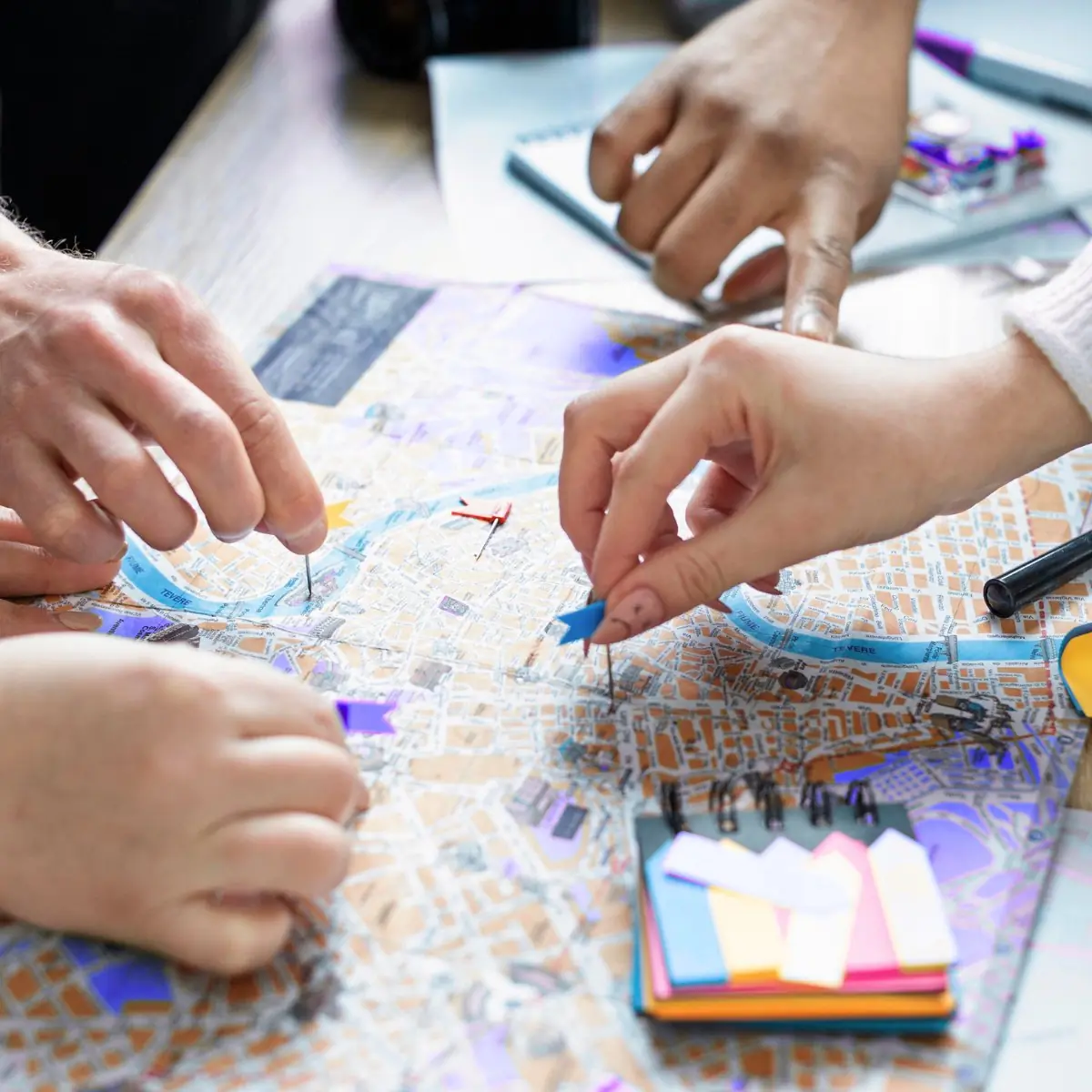 "Zwei Personen planen gemeinsam an einer Stadtkarte mit farbigen Markierungsfähnchen – Sinnbild für kollaborative Netzplanung und Projektmanagement im Glasfaserausbau"